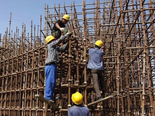 Construction workers erect scaffolding on a building site located on the outskirts of Beijing